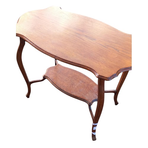 348 - AN ANTIQUE (OAK ) SHAPED WINDOW TABLE WITH BOTTOM SHELF