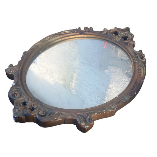 384 - AN ORNATE GILT FRAMED SHAPED MIRROR