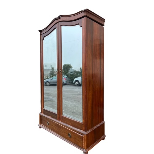 409 - A MAHOGANY SHAPED DOUBLE ROBE WITH MIRRORED DOORS