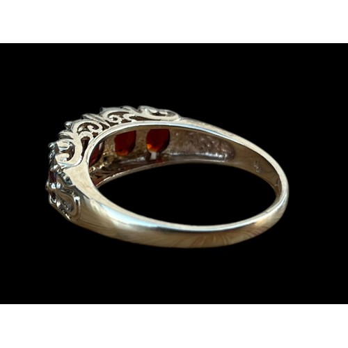 621 - A 9CT GOLD CHUNKY 5 STONE OVAL CUT GARNET SET RING WITH A CURVED MOUNT ON A HEAVY SHANK WEIGHS 4.30G