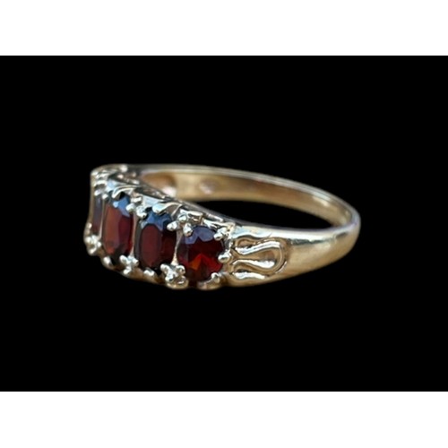 621 - A 9CT GOLD CHUNKY 5 STONE OVAL CUT GARNET SET RING WITH A CURVED MOUNT ON A HEAVY SHANK WEIGHS 4.30G