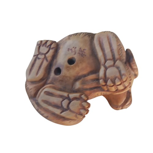 679 - A NETSUKE DOG WITH MARKINGS