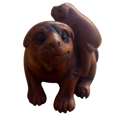 552 - A NETSUKE DOG WITH MARKINGS