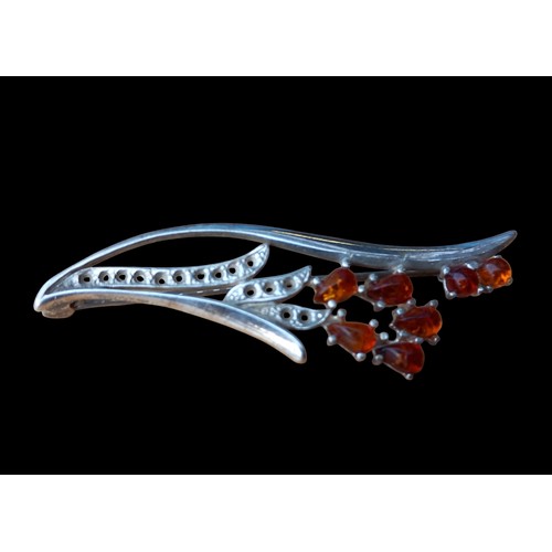 554 - A SILVER & AMBER FLORAL DESIGN BROOCH