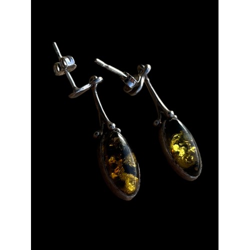 184 - AN ORNATE PAIR OF DROP SILVER EARRINGS WITH AMBER STONES