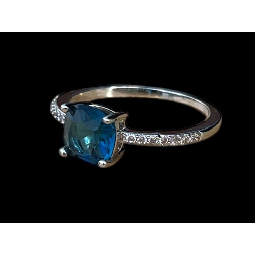 196 - A SILVER GEM SET RING WITH A BLUE CENTRE STONE