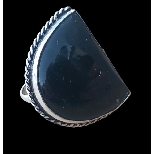 210 - AN ORNATE SILVER RING SET WITH A BLACK STONE