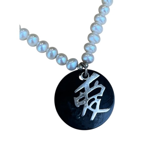 268 - A PEARL AND JET STONE NECKLACE WITH SILVER CATCH AND SET  WITH JASE AND SILVER EMBLEMN