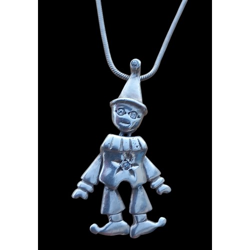 422 - A GEM SET ARTICULATED SILVER CLOWN PENDANT ON A SILVER SNAKE CHAIN