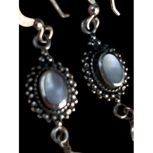 424 - AN ORNATE PAIR OF SILVER EARRINGS SET WITH MOONSTONE STYLE STONES