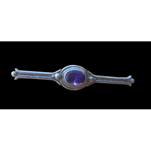 375 - A SILVER BAR BROOCH SET WITH AN AMETHYST STONE