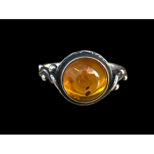 453 - AN ORNATE SILVER RING SET WITH A GENEROUS AMBER STONE