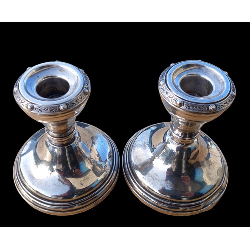 551 - A PAIR OF SILVER CANDLESTICK WITH A CELTIC BORDER