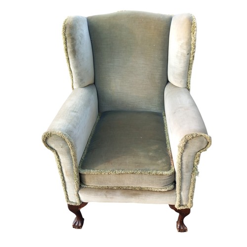 594 - AN ANTIQUE WINGBACK ARMCHAIR ON BALL AND CLAW FOOT