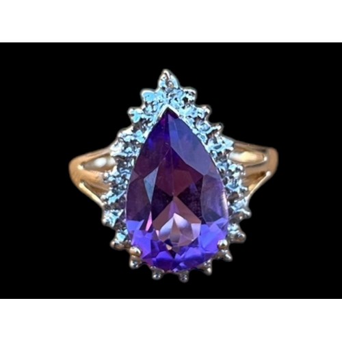 570 - A 9ct GOLD PEAR SHAPED AMETHYST AND DIAMOND CHIP RING