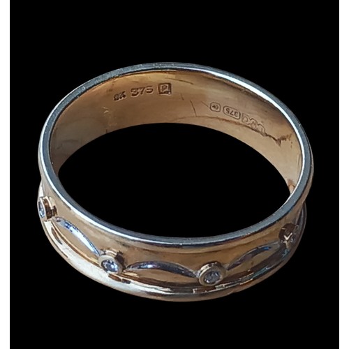 569 - A 9ct GOLD BAND WITH DOLPHIN AND WAVE PATTERN IN WHITE GOLD SET WITH 8 DIAMONDS 3.08grm