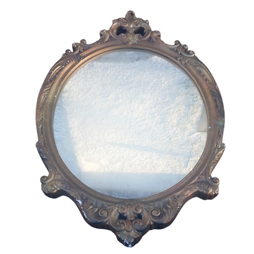 50 - AN ORNATE GILT FRAMED SHAPED MIRROR