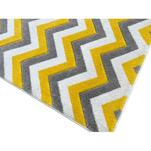 79 - AN AS NEW RUBY RANGE 80X150 MUSTARD  SILVER CHERRON RUG