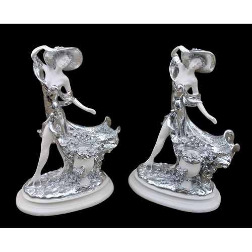 101 - A PAIR OF WHITE AND SILVER FINISHED FIGURED CANDLE HOLDERS