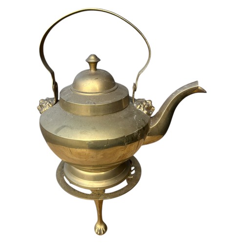 102 - A HEAVY BRASS KETTLE WITH LIONS HEADS AND LION TRIVOT