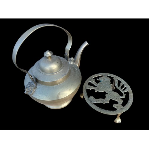 102 - A HEAVY BRASS KETTLE WITH LIONS HEADS AND LION TRIVOT