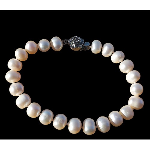 206 - A NATURAL PEARL BRACELET WITH A FLORAL CLASP