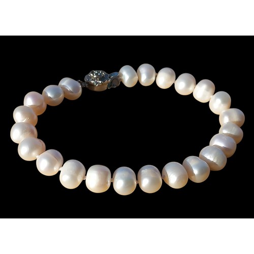 206 - A NATURAL PEARL BRACELET WITH A FLORAL CLASP