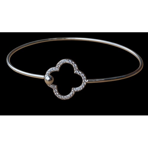 216 - A SILVER BANGLE WITH GEM SET CLOVER DESIGN