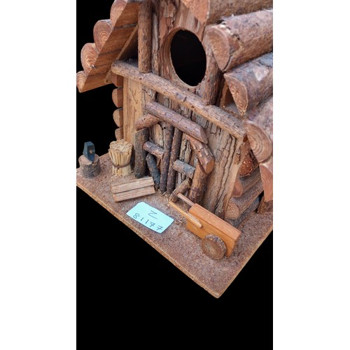 320 - A HIGHLY DECORATIVE WOODEN LOG CABIN BIRD HOUSE