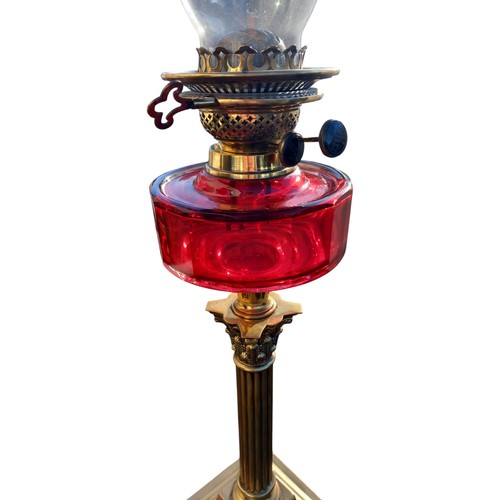 340 - A VICTORIAN RUBY BOWL OIL LAMP WITH DUPLEX DOUBLE BURNER ON A GOOD BRASS CORINTHIAN PILLAR