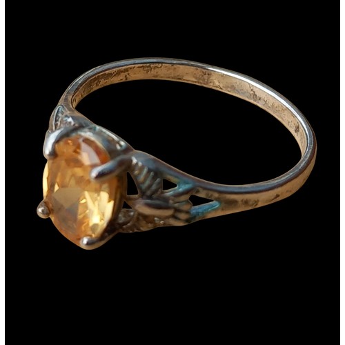 225 - AN OPENWORK SILVER RING WITH A CITRINE STONE