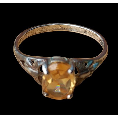 225 - AN OPENWORK SILVER RING WITH A CITRINE STONE