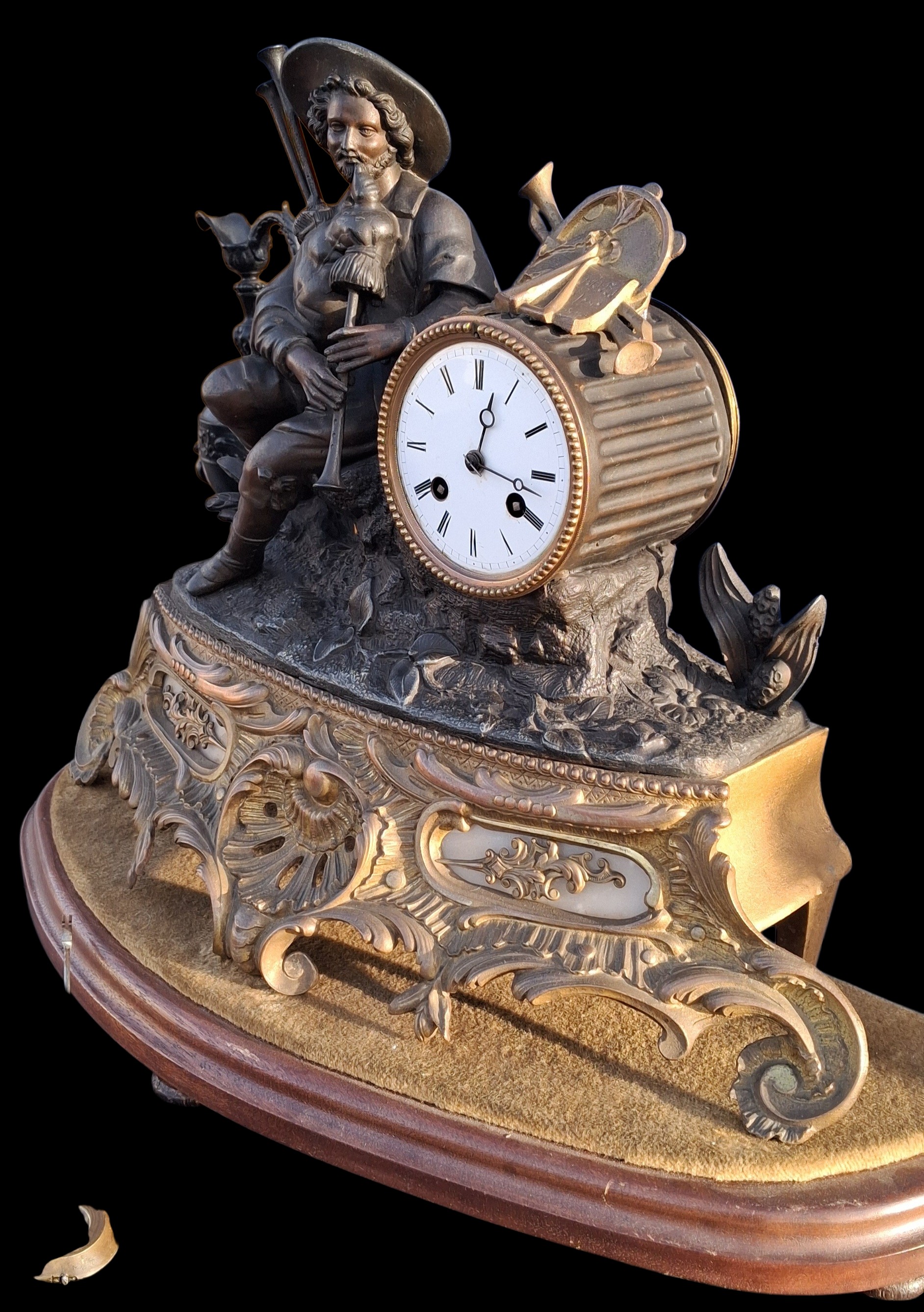 A BRASS FRENCH CLOCK WITH SPELTER FIGURE ON PLINTH