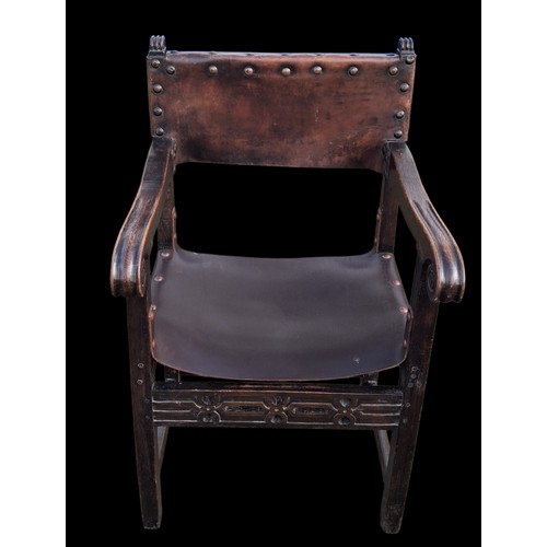 331 - AN ANTIQUE CARVED OAK CHAIR IN THE ANTIQUE STUDDED LEATHER FINISH