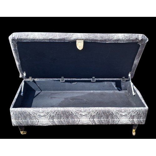 121 - A GREY POUFFE ON CASTORS WITH STORAGE