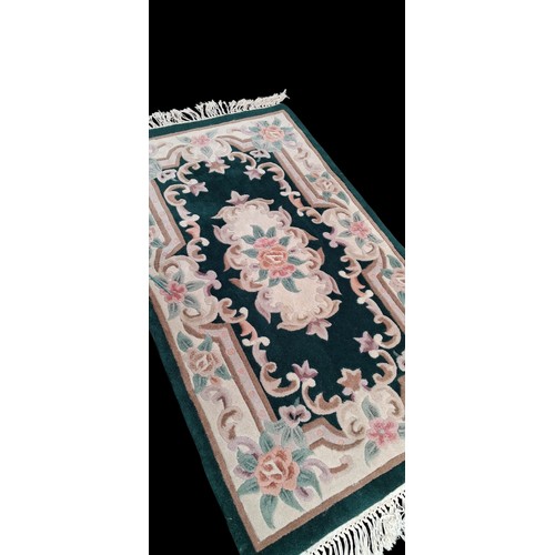 76 - A GREEN PATTERNED RUG