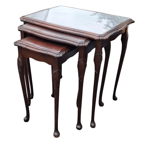 83 - A GLASS TOPPED NEST OF THREE MAHOGANY NEST OF TABLES