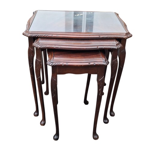 83 - A GLASS TOPPED NEST OF THREE MAHOGANY NEST OF TABLES