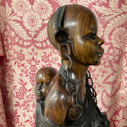 79 - African Wooden Sculpture - R. Kyengo (d.1993). 'Kikuyu woman carrying baby and bananas'. Carved wood... 