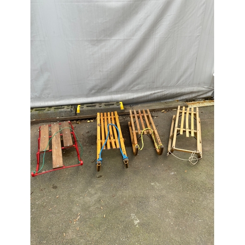 464 - Collection of four snow sleds. 3 x wooden, 1 x metal.