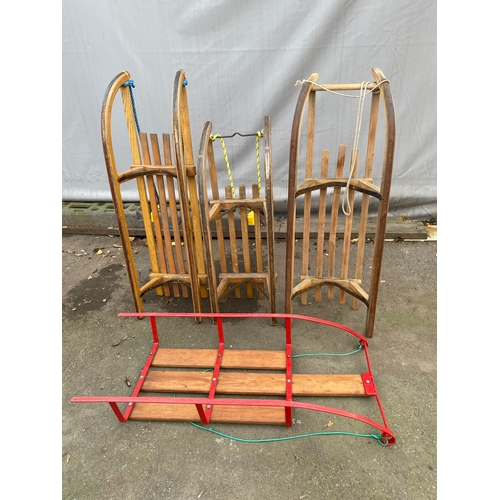 464 - Collection of four snow sleds. 3 x wooden, 1 x metal.