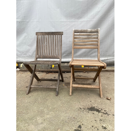 479 - Two teak garden chairs.