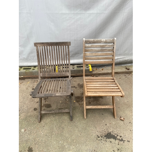 479 - Two teak garden chairs.