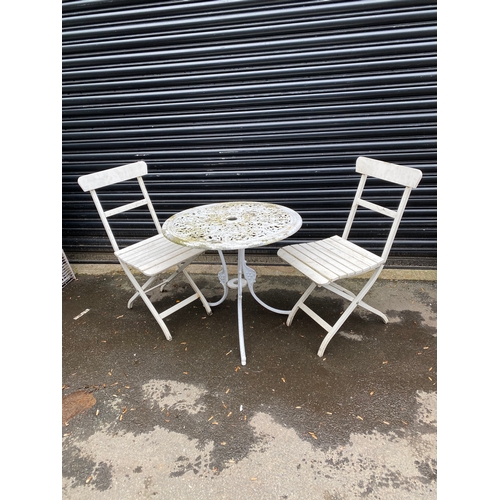 359 - White metal garden table with two white foldable chairs.