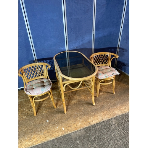 198 - Compact cane table and two chairs with glass top.

Dimensions - 39