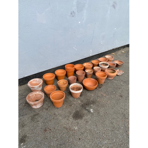 319 - A large collection of small terracotta pots.