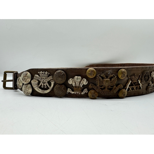 141 - Early Leather belt with various Military Regimental Badges / Buttons / Pips circa WW1