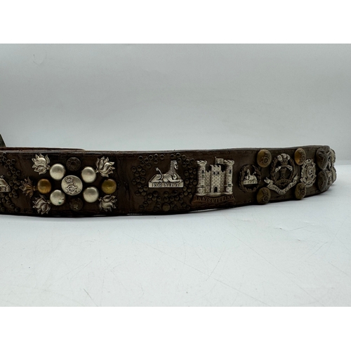 141 - Early Leather belt with various Military Regimental Badges / Buttons / Pips circa WW1