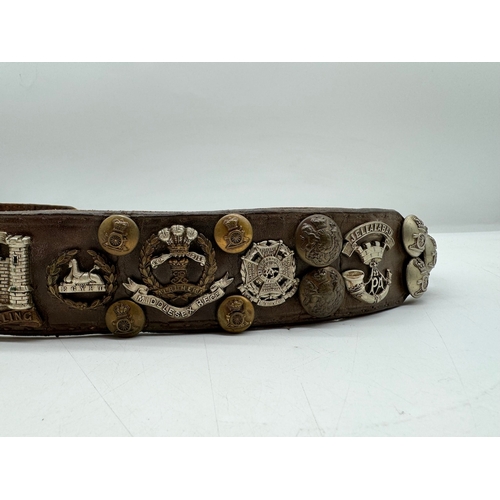 141 - Early Leather belt with various Military Regimental Badges / Buttons / Pips circa WW1