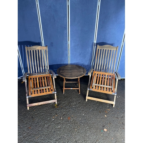 502 - A pair of Alexander rose recliner lounge chairs and side table.